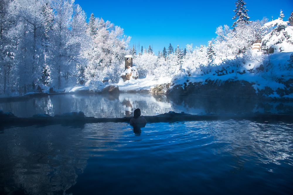 Person soaking in Steamboat hot springs in winter